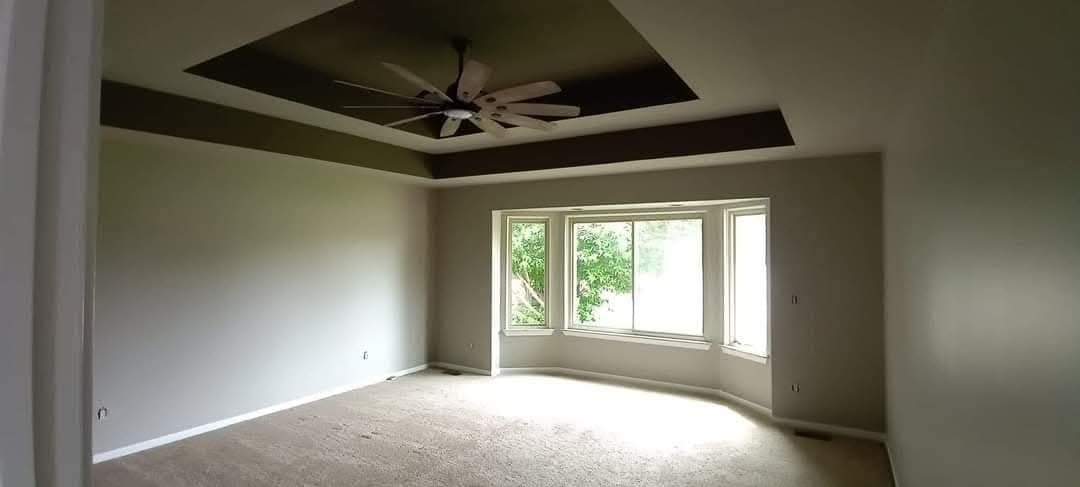 A&M Brownstown room with a contrasting tray ceiling and light painted walls